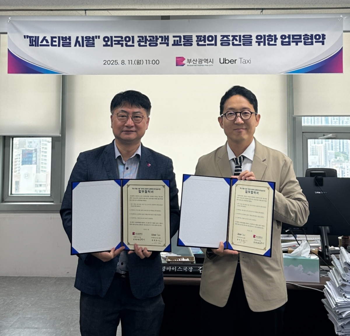 우버 택시 코리아 송진우 총괄(우)과 부산시 관광마이스국 김현재 국장(좌)이 지난 11일 개최된 업무협약식에서 기념촬영을 하고 있다./사진제공=우버 택시