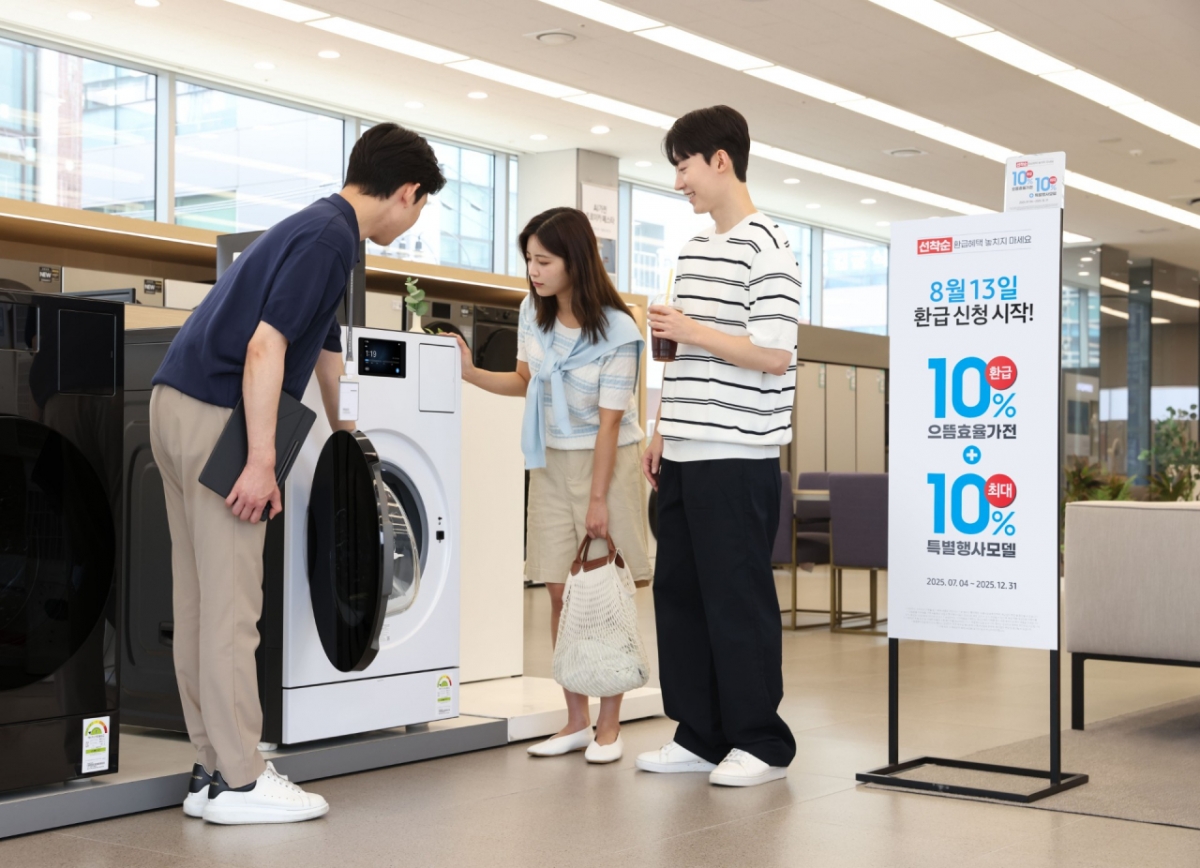 삼성전자 모델이 에너지 소비효율 1등급의 '세탁건조기'와 '에어컨' 제품의 설명을 듣고 있다./사진제공=삼성전자