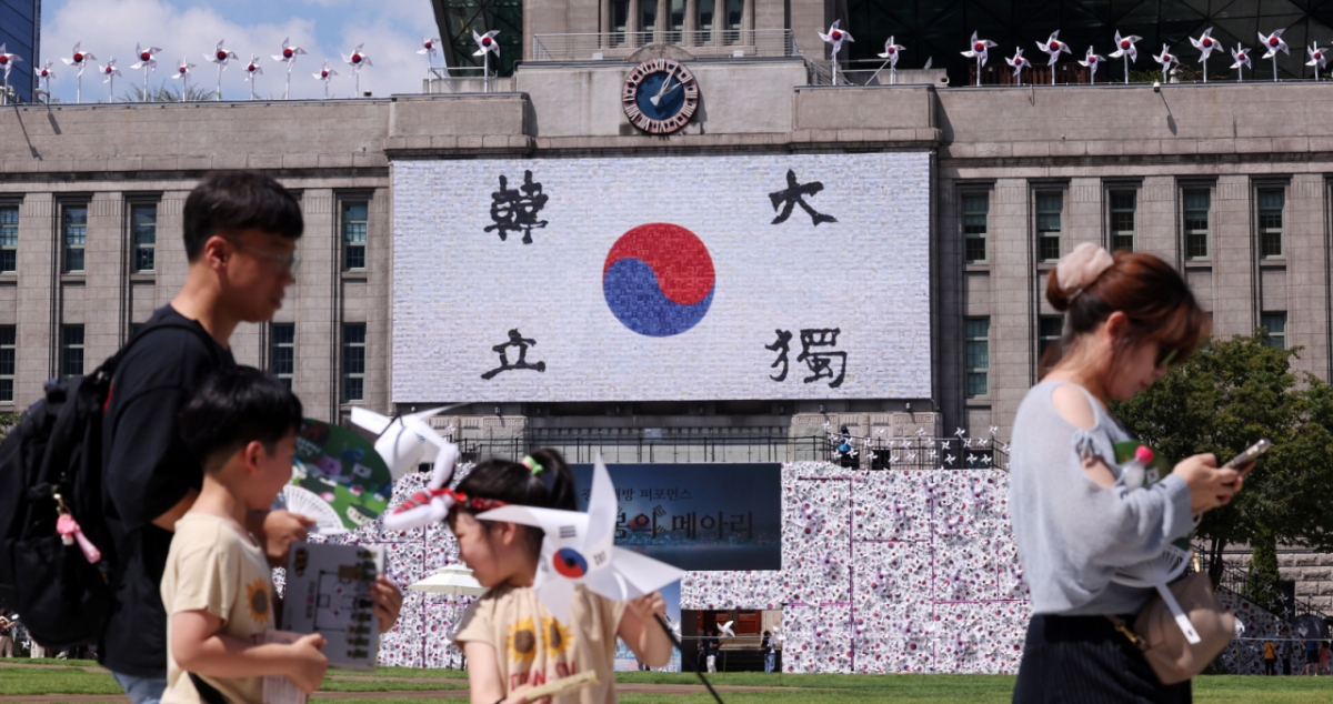  제80주년 광복절을 앞둔 지난 10일 서울 중구 서울도서관 입구에 조성된 태극기 언덕과 꿈새김판에 걸린 태극기 앞으로 시민들이 발걸음을 옮기고 있다./사진=뉴스1