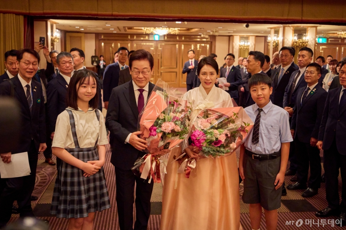 (서울=뉴스1) 이재명 기자 = 한일 정상회담을 위해 일본을 방문중인 이재명 대통령과 김혜경 여사가 23일(현지시간) 일본 도쿄의 한 호텔에서 열린 재일동포 오찬 간담회에서 화동들에게 꽃다발을 전달 받은 후 기념촬영을 하고 있다. (이재명 대통령 SNS. 재판매 및 DB금지) 2025.8.25/뉴스1 Copyright © 뉴스1. All rights reserved. 무단 전재 및 재배포, AI학습 이용 금지.