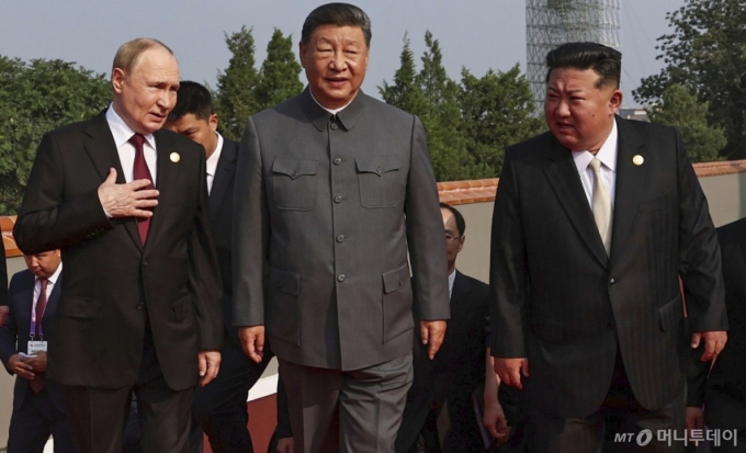 김정은 북한 국무위원장이 3일(현지시간) 시진핑 중국 국가주석, 블라디미르 푸틴 러시아 대통령과 얘기하며 '중국 인민 항일 전쟁 및 세계 반파시스트 전쟁 승리(전승절)' 80주년 기념 열병식이 열리는 베이징 톈안먼광장에 도착하고 있다. / AP=뉴시스