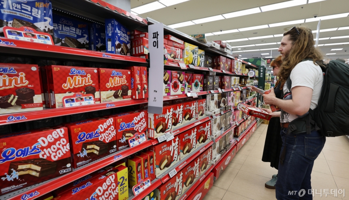 (서울=뉴스1) 박지혜 기자 = 지난달 라면·과자 등 K푸드의 대미(對美) 수출이 큰 폭으로 줄었다. 미국의 상호관세 불확실성으로 상반기에 수출이 앞당겨진 영향이라는 분석이다.  22일 한국농수산식품유통공사(KATI)에 따르면 7월 농수산식품 대미 수출액은 5437만 달러로 전년 동월 대비 1.6% 감소했다. 라면 수출액은 17.8% 줄었고, 과자류는 25.9% 감소하며 가장 큰 폭의 하락세를 보였다.  사진은 이날 서울의 한 대형마트 과자코너를 찾은 외국인 관광객 모습. 2025.8.22/뉴스1  Copyright © 뉴스1. All rights reserved. 무단 전재 및 재배포,  AI학습 이용 금지. /사진=(서울=뉴스1) 박지혜 기자