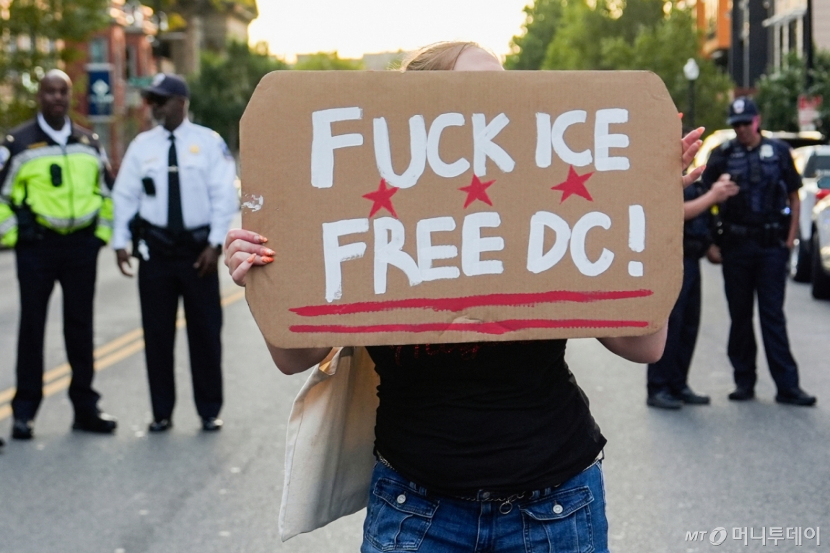 지난달 21일(현지 시간) 워싱턴에서 한 시민이 도널드 트럼프 대통령의 연방 법 집행기관·주 방위군 동원에 반대하며 시위를 벌이고 있다. /AP=뉴시스