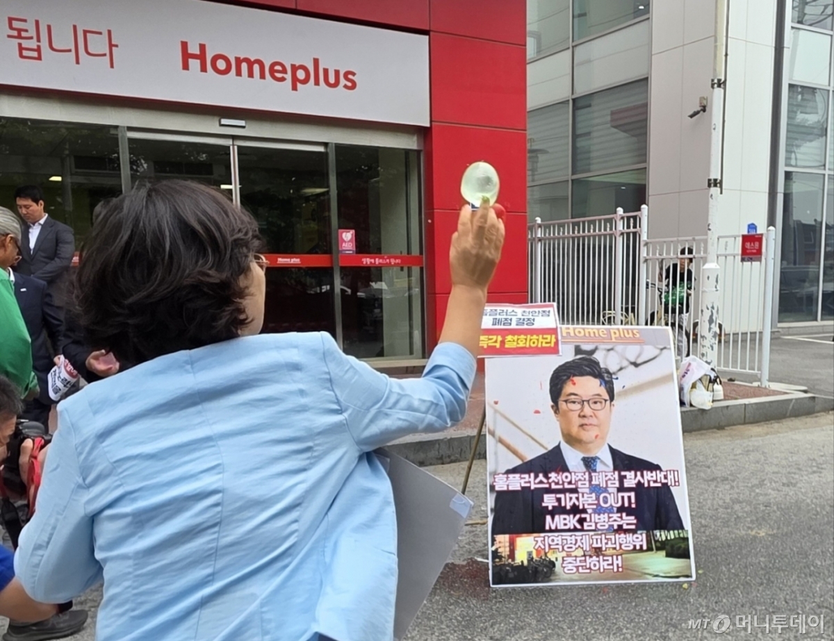 (천안=뉴스1) 이시우 기자 = 마트 노동자들이 2일 천안시 동남구 홈플러스 천안점 앞에서 열린 폐점 반대 기자회견에서 김병주 MBK파트너스 회장을 규탄하며 얼굴 사진에 물풍선을 던지고 있다. 2025.6.2/뉴스1 Copyright © 뉴스1. All rights reserved. 무단 전재 및 재배포, AI학습 이용 금지. /사진=(천안=뉴스1) 이시우 기자