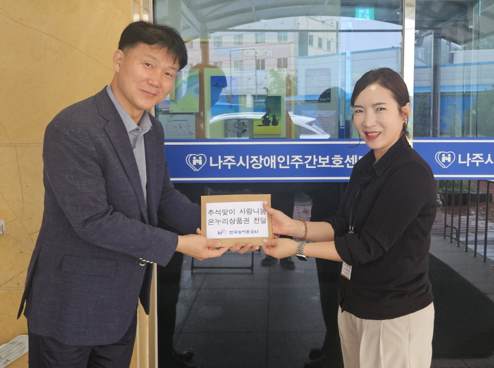 김현석 농어촌공사 부장(왼쪽)이 추석명절 맞아 나주시 지역 아동센터에 상품권을 전달하고 있다. /사진제공=농어촌공사