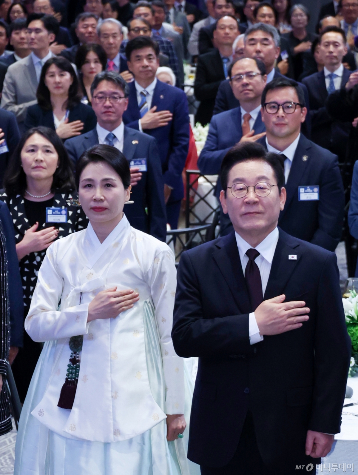 [뉴욕=뉴시스] 최동준 기자 = 이재명 대통령과 김혜경 여사가 22일(현지 시간) 미국 뉴욕의 한 호텔에서 열린 동포 간담회에서 참석자들과 국민의례를 하고 있다. 2025.09.23. photocdj@newsis.com /사진=