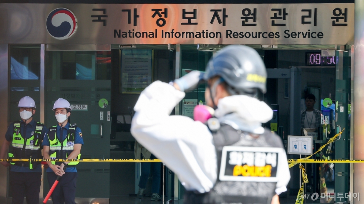 (대전=뉴스1) 김진환 기자 = 27일 오전 대전 유성구 국가정보자원관리원 화재현장에서 경찰 과학수사대 화재감식 관계자들이 건물 내부로 이동하고 있다.   전산 자원을 통합 관리하는 행정안전부 산하 국가정보자원관리원에서 지난 26일 오후 배터리 교체 작업 중 화재가 발생, 정부 온라인 서비스 70개가 마비됐다. 2025.9.27/뉴스1  Copyright © 뉴스1. All rights reserved. 무단 전재 및 재배포,  AI학습 이용 금지. /사진=(대전=뉴스1) 김진환 기자