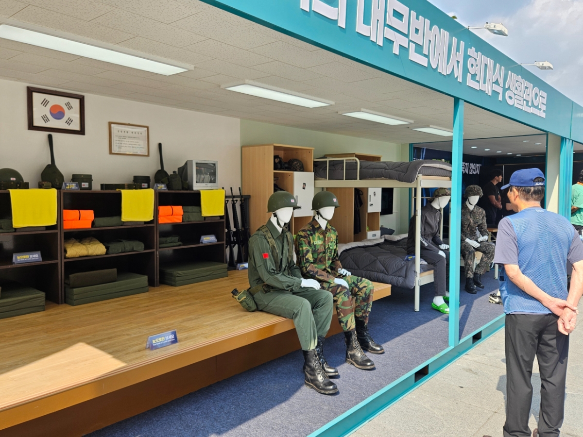 1일 정오쯤 서울 광화문 광장에 옛날 생활관과 현대식 생활관을 재현해 놓은 부스. 한 시민이 생활관을 보며 추억에 빠진 모습이다./사진=박상혁 기자. 