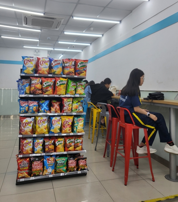 베트남 호치민시에 위치한 한 GS25 매장. 매대에는 오리온의 오스타, 스윙, 마시타 등 스낵이 빼곡이 진열돼있다. 베트남인들은 GS25 매장 의자에 앉아 음식을 먹고 마시거나 친구를 만나는 등 시간을 보낸다./사진=차현아 기자. 