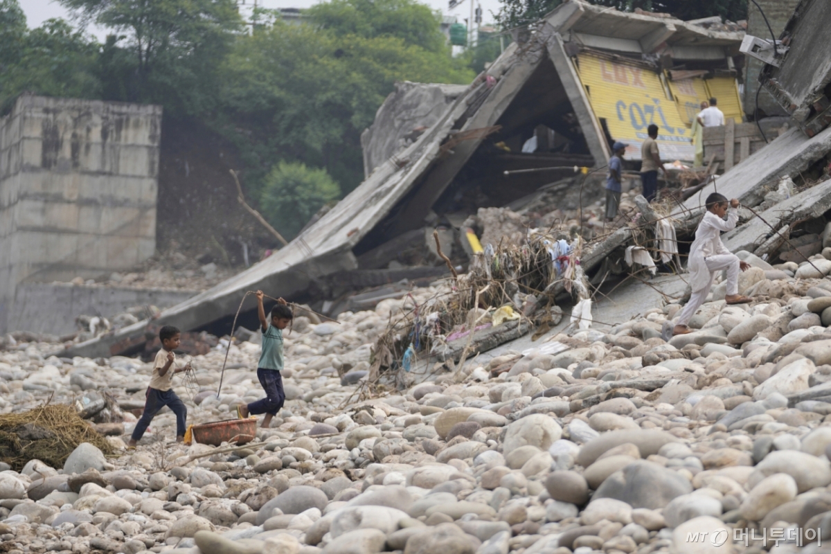 지난 8월29일(현지 시간) 인도 잠무의 돌발 홍수 피해 주택 잔해에서 어린이들이 철근을 수거해 옮기고 있다. /AP=뉴시스