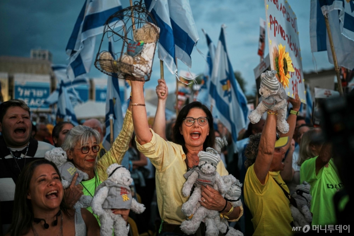 [텔아비브=AP/뉴시스] 13일(현지 시간) 이스라엘 텔아비브의 ‘인질 광장'에서 시민들이 가자지구에 억류된 이스라엘 인질들의 석방을 기다리고 있다. 이스라엘과 하마스의 '가자 평화 구상' 1단계 합의에 따라 이스라엘 인질 20명 전원(시신 28구 포함)과 팔레스타인 수감자 2000명의 교환이 이날 이루어진다. 2025.10.13. /사진=민경찬