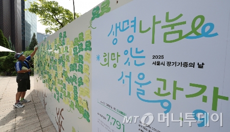 지난달 8일 서울광장에서 열린 2025 서울시 장기기증의 날 행사를 찾은 한 시민이 희망의 메시지를 붙이고 있다. /사진=(서울=뉴스1) 박지혜 기자