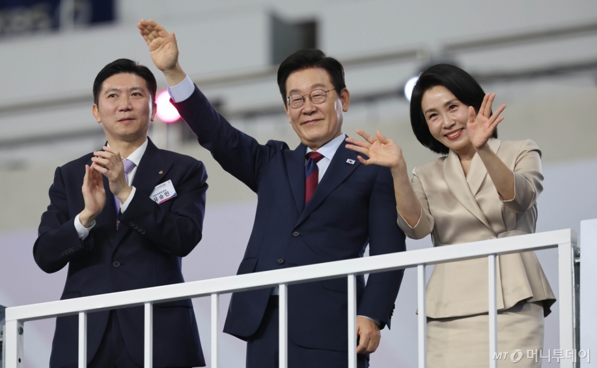 [부산=뉴시스] 황준선 기자 = 이재명 대통령과 김혜경 여사가 17일 오후 부산 연제구 부산아시아드주경기장에서 열린 제106회 전국체육대회 개회식에 참석해 입장하는 선수단을 환영하고 있다. 왼쪽은 유승민 대한체육회장. 2025.10.17. hwang@newsis.com /사진=황준선