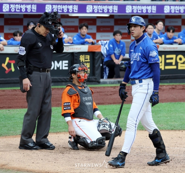 한화 김경문 감독(왼쪽에서 3번째)이 18일 삼성과 2025 KBO 포스트시즌 플레이오프 1차전 3회초 무사 1, 3루에서 구자욱의 항의 관련 내용을 확인하고 있다.