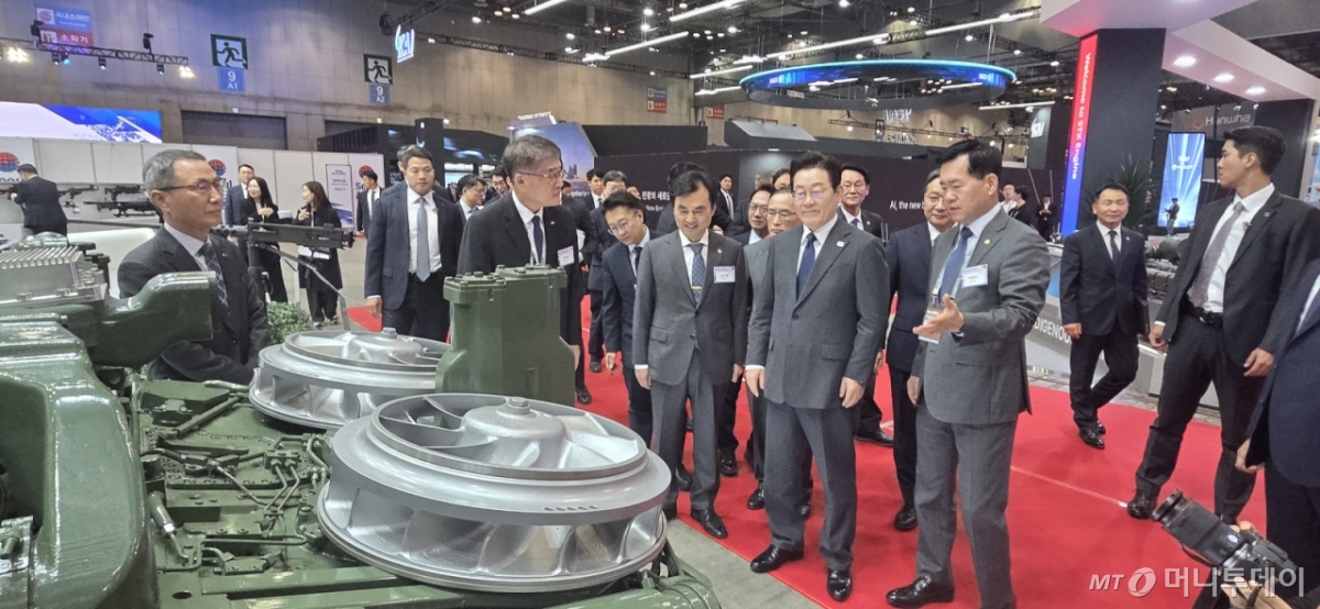 [창원=뉴시스] 강경국 기자 = 이재명 대통령이 20일 ADEX 2025 전시회에서 SNT그룹 부스를 방문해 K2전차 4차 양산 적용 예정인 국산 파워팩에 대한 설명을 듣고 있다. (사진=SNT다이내믹스 제공). 2025.10.20. photo@newsis.com  *재판매 및 DB 금지 /사진=강경국