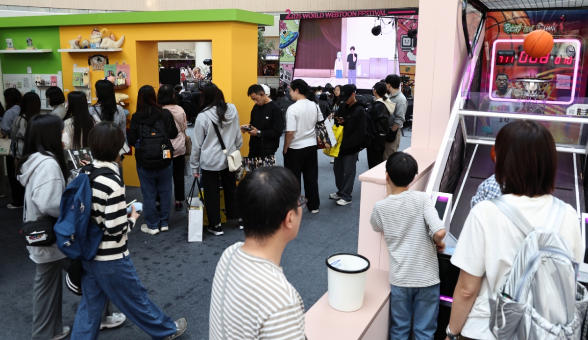 19일 오후 서울 송파구 롯데월드 아이스링크에 마련된 '2025 월드 웹툰 페스티벌' 행사장에서 관람객들이 웹툰 전시를 둘러보고 있다.  / 사진 = 뉴스1 