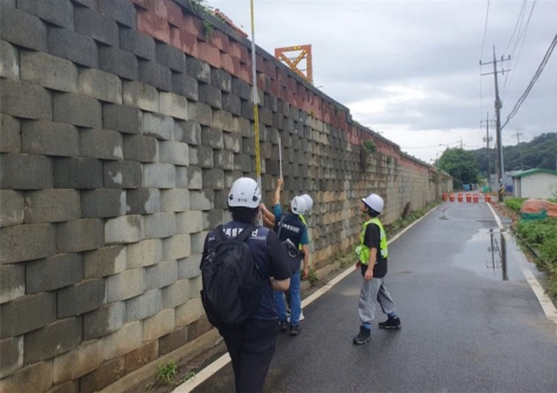 '안전예방 핫라인'을 통해 접수된 옹벽 균열에 대해 경기도 관계자가 점검을 하고 있다./사진제공=경기도