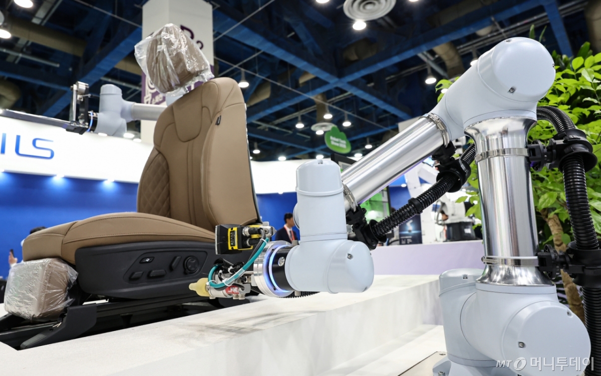 '2025 스마트테크 코리아'에서 관람객들이 로봇을 활용한 제조시스템을 살펴보고 있다./사진=뉴스1. 