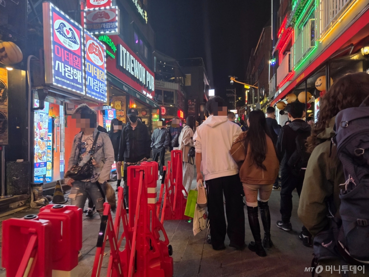 24일 저녁 서울 용산구 이태원역 일대 골목길에 설치된 이동식 중앙 분리대를 따라 시민들이 우측통행을 하는 모습./사진=김서현 기자.
