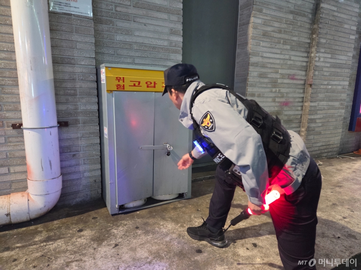 24일 저녁 서울 용산구 이태원역 일대 골목길에서 기동순찰대원이 고압전선함이 잘 잠겼는지 확인하는 모습./사진=김서현 기자.