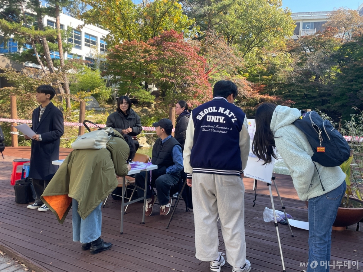 28일 서울 관악구 서울대학교 캠퍼스에서 열린 이태원 참사 3주기 추모제 '기억은 영영' 부스에서 학생들이 추모글을 남기고 있다. /사진=이현수 기자.