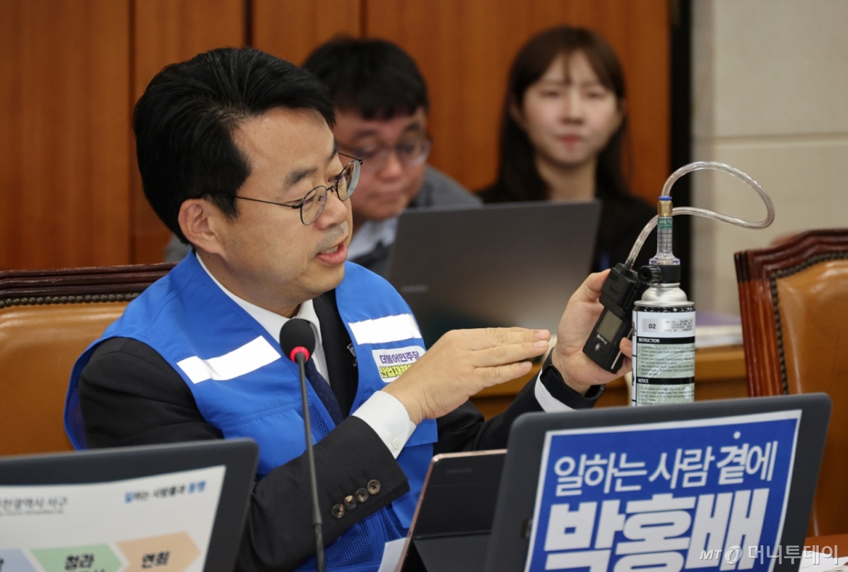 [서울=뉴시스] 김금보 기자 = 박홍배 더불어민주당 의원이 30일 서울 여의도 국회에서 열린 기후에너지환경노동위원회 국정감사에서 안전조끼를 입고 가스감지기를 시연하며 질의를 하고 있다. 2025.10.30. kgb@newsis.com /사진=김금보