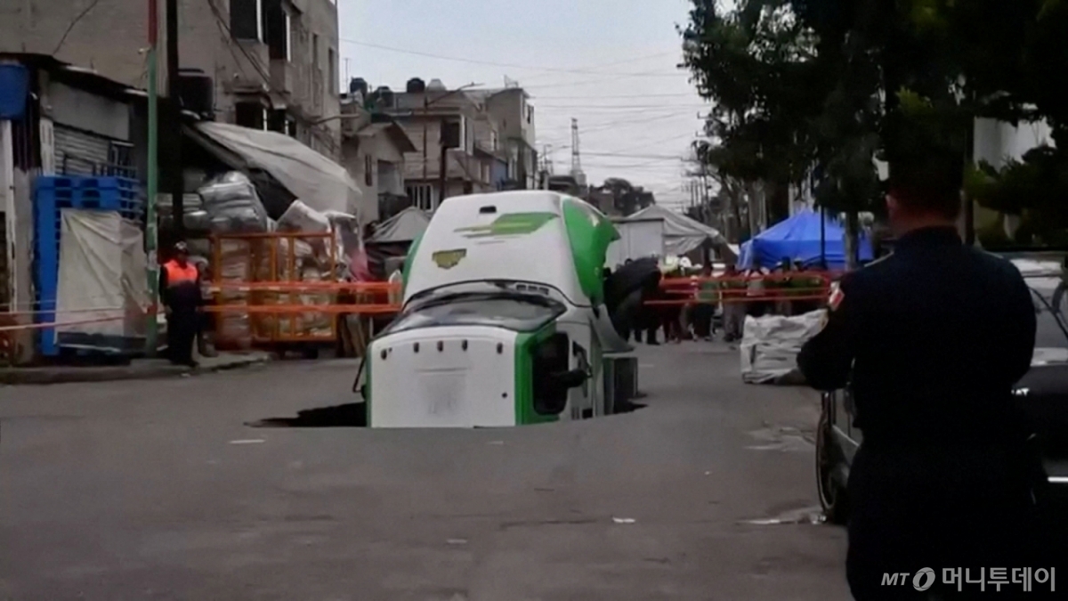 (멕시코시티 로이터=뉴스1) 권영미 기자 = 13일(현지시간) 멕시코 멕시코시티 이스타팔라파 지역에서 탄산음료 배달 트럭이 싱크홀에 빠졌다. 한 시민이 이를 지켜보고 있다. ⓒ 로이터=뉴스1 Copyright © 뉴스1. All rights reserved. 무단 전재 및 재배포, AI학습 이용 금지. /사진=(멕시코시티 로이터=뉴스1) 권영미 기자