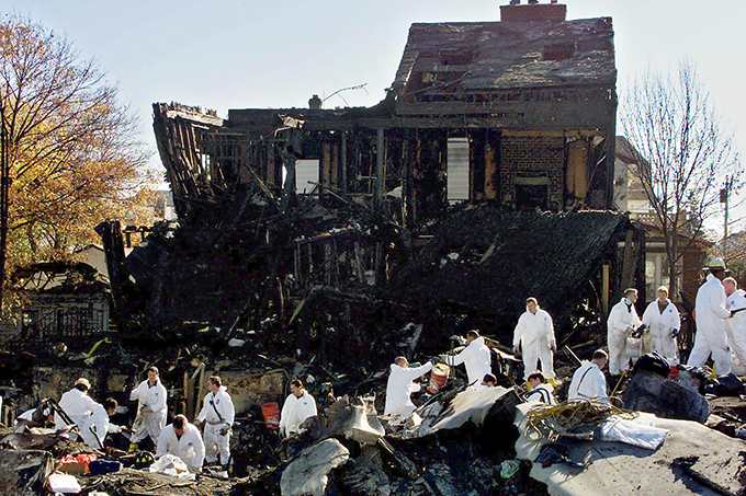 2001년 11월 12일 미국 뉴욕에서 아메리칸 항공 587편이 추락해 탑승객과 승무원 260명과 지상에 있던 5명 등 265명이 사망했다. 사진은 사고 이틀 뒤인 14일 소방관들이 추락 현장에서 증거물과 유해를 수습하고 있는 모습이다. /AFPBBNews=뉴스1