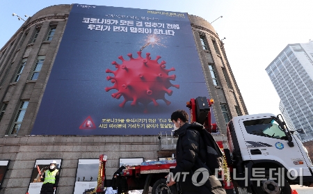 2020년 11월 서울 중구 시청도서관 외벽에 코로나19 확산세를 막기 위한 '천만시민 긴급 멈춤 기간' 현수막이 설치되고 있다./사진=김휘선 기자 hwijpg@