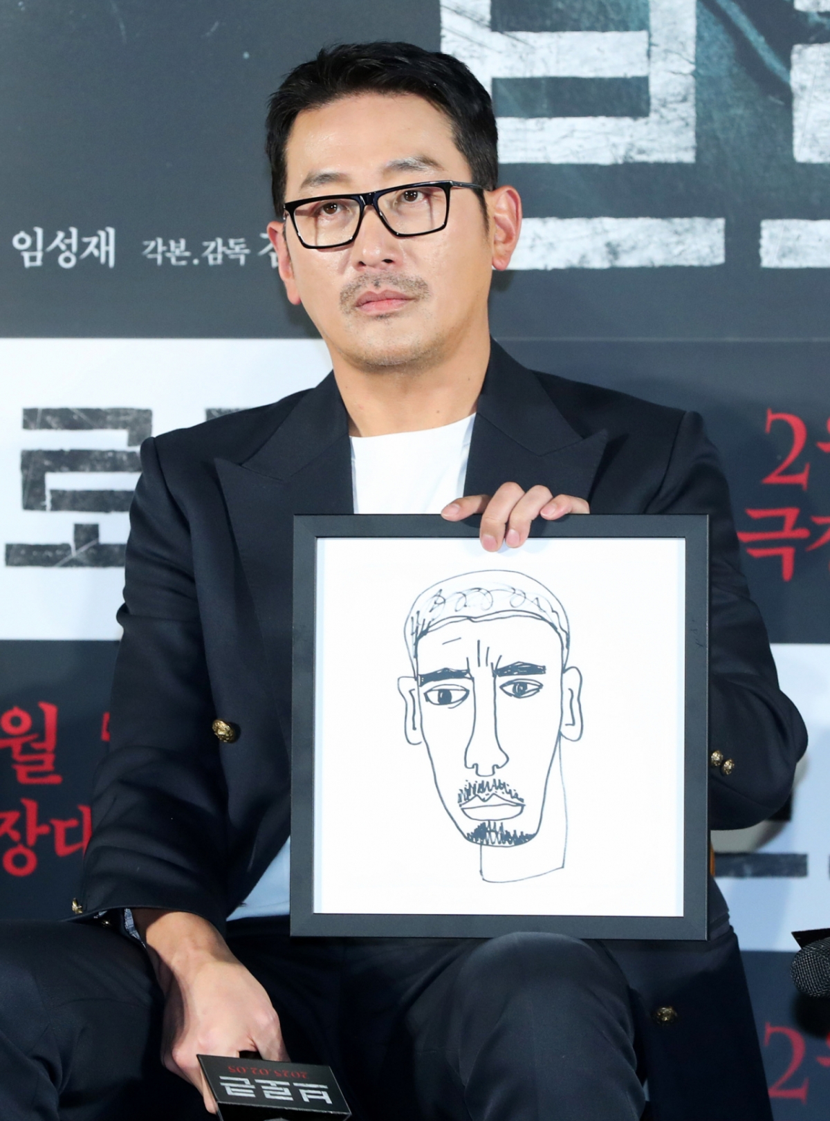  배우 하정우가 지난 1월 영화 제작보고회에서 직접 그린 그림을 들어보이는 모습. / 사진 = 뉴시스 