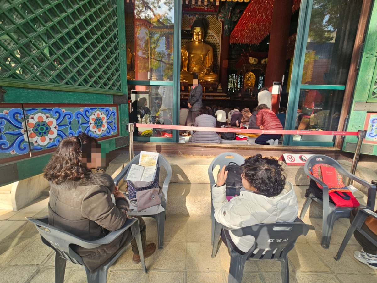 12일 오후 서울 종로구 조계사에서 불교 신자가 기도문을 읽으며 염주를 돌리는 모습./사진=박상혁 기자.