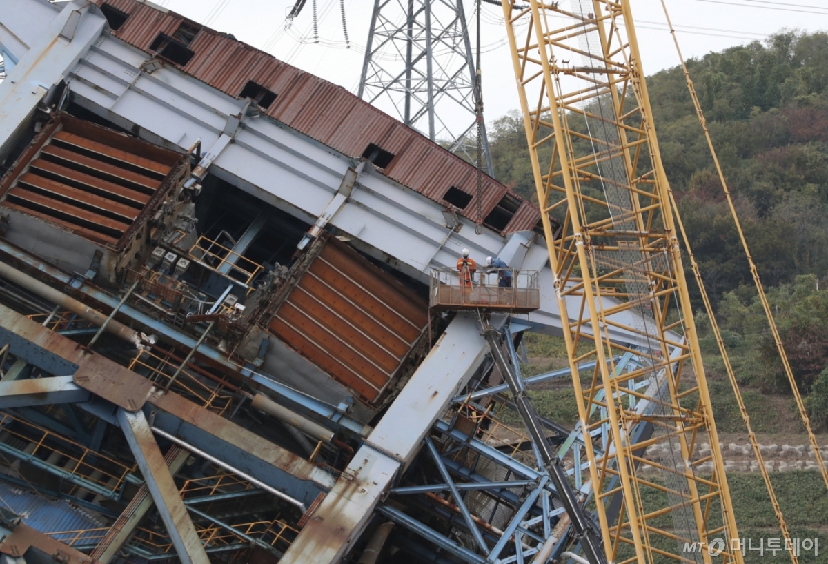 (울산=뉴스1) 조민주 기자 = 한국동서발전 울산화력발전소 보일러 타워 붕괴 사고 일주일 째인 12일 사고 현장에서 크레인으로 5호기 상부 구조물을 고정하는 작업이 이뤄지고 있다. 2025.11.12/뉴스1 Copyright © 뉴스1. All rights reserved. 무단 전재 및 재배포, AI학습 이용 금지. /사진=(울산=뉴스1) 조민주 기자