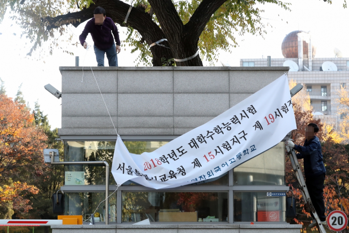 2017년 11월 경북 포항 지진 여파로 대학수학능력시험이 연기되면서 서울 서대문구 한 수능 시험장에서 학교 관계자들이 현수막을 내리는 모습./사진=머니투데이DB 