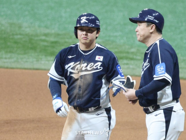 문현빈(왼쪽)이 체코와 2차전에서 안타를 날리고 이동욱 코치에게 장비를 넘겨주고 있다. /사진=김진경 대기자