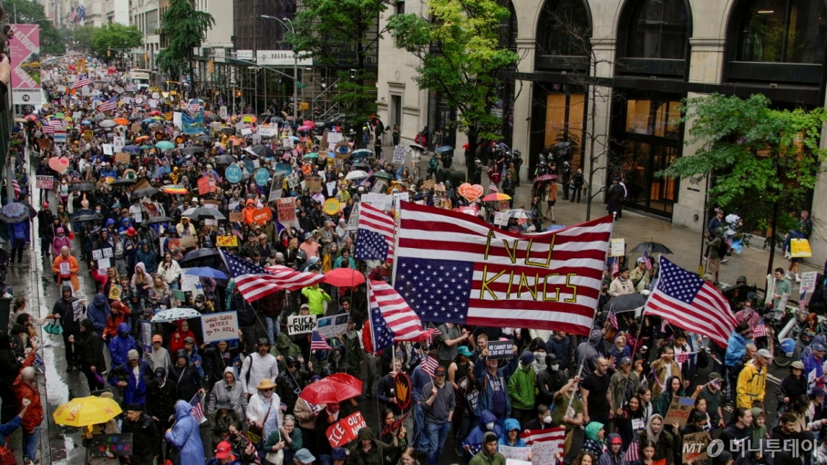 (뉴욕 로이터=뉴스1) 류정민 특파원 = 14일(현지시간) 미국 뉴욕에서 도널드 트럼프 미국 대통령의 정책에 반대하는 '노킹스'(No Kings) 시위가 열린 가운데, 시위대가 저항의 의미를 담아 성조기를 거꾸로 들고 거리 행진을 하고 있다. 이날은 성조기의 국기 채택을 기념하는 '미국 국기의 날'(플래그 데이, Flag Day)이기도 하다. 미 수도 워싱턴DC에서는 트럼프 대통령이 주재하는 미 육군 창설 250주년 군사 퍼레이드가 열린다. 2025.6.14  ⓒ 로이터=뉴스1  Copyright © 뉴스1. All rights reserved. 무단 전재 및 재배포,  AI학습 이용 금지. /사진=(뉴욕 로이터=뉴스1) 류정민 특파원