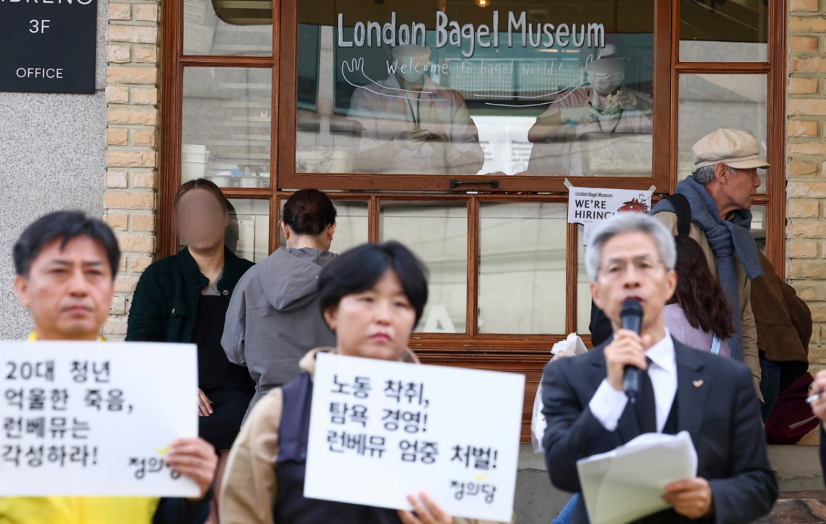 지난달 30일 서울 종로구 런던베이글뮤지엄 매장 앞에서 권영국 정의당 대표가 런던베이글뮤지엄 청년 노동자 과로사 규탄 및 책임 촉구 기자회견을 하고 있는 가운데, 런던베이글뮤지엄 매장 안에서 청년 노동자들이 업무를 하고 있다./사진=뉴스1.