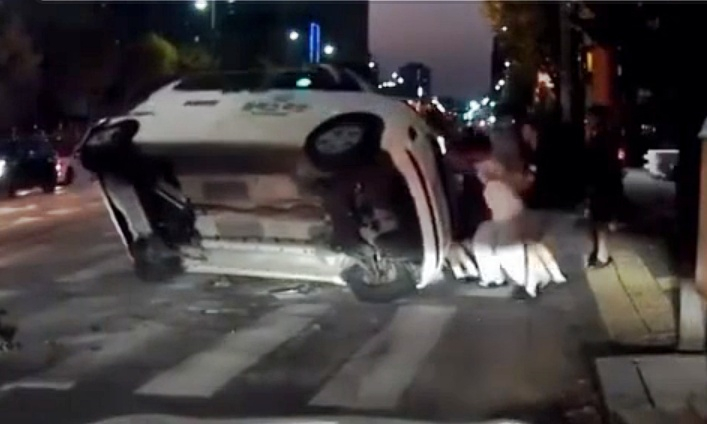 도로 한복판에서 신호 위반한 택시와 충돌해 옆으로 넘어진 차량을 시민들이 함께 일으켜 세우는 모습이 공개됐다./사진=인스타그램 'bobaedream'