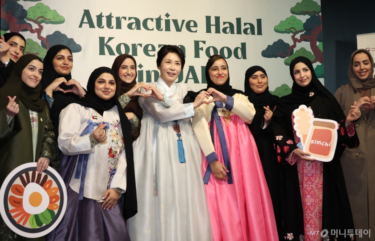 [아부다비=뉴시스] 최동준 기자 = 김혜경 여사가 19일(현지 시간) 아부다비 주UAE한국문화원에서 열린 할랄 K-푸드 홍보행사에서 참석자들과 기념촬영을 하고 있다. 2025.11.19. photocdj@newsis.com /사진=