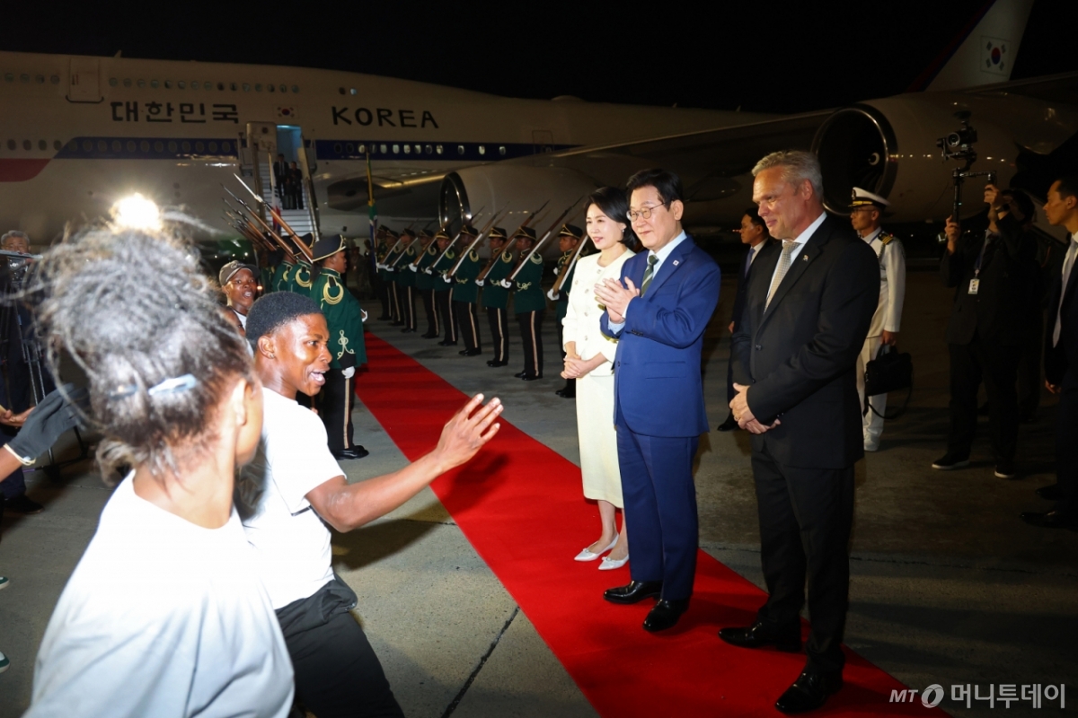 [요하네스버그=뉴시스] 최동준 기자 = G20 정상회의에 참석하는 이재명 대통령과 김혜경 여사가 21일(현지 시간) 남아프리카공화국 요하네스버그 O.R. 탐보 국제공항에 도착해 공군1호기에서 내려 환영공연을 보고 있다. 2025.11.22. photocdj@newsis.com /사진=