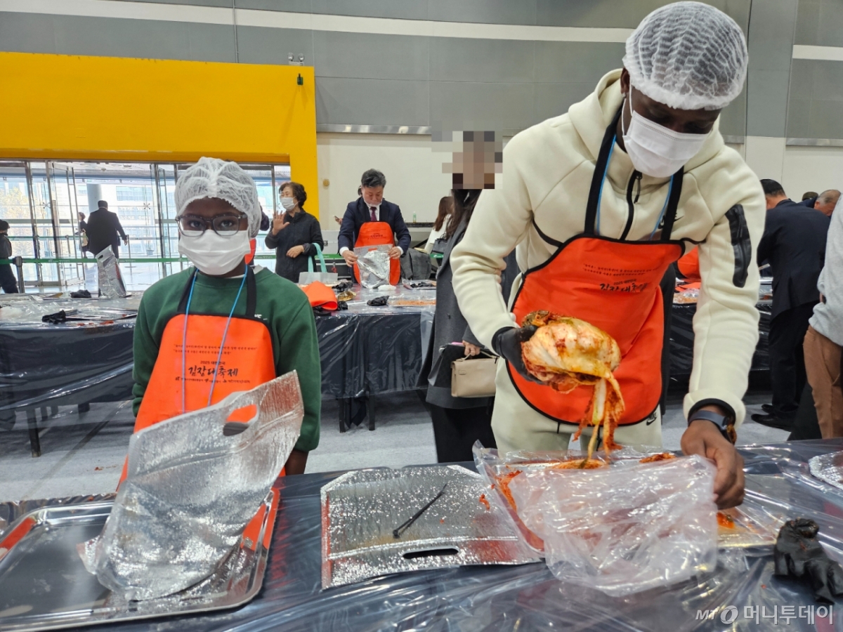 미군 하사 왈리 암브로스씨(34·오른쪽)이 아들과 함께 김치 담그기 체험을 하고 있다./=정세진 기자