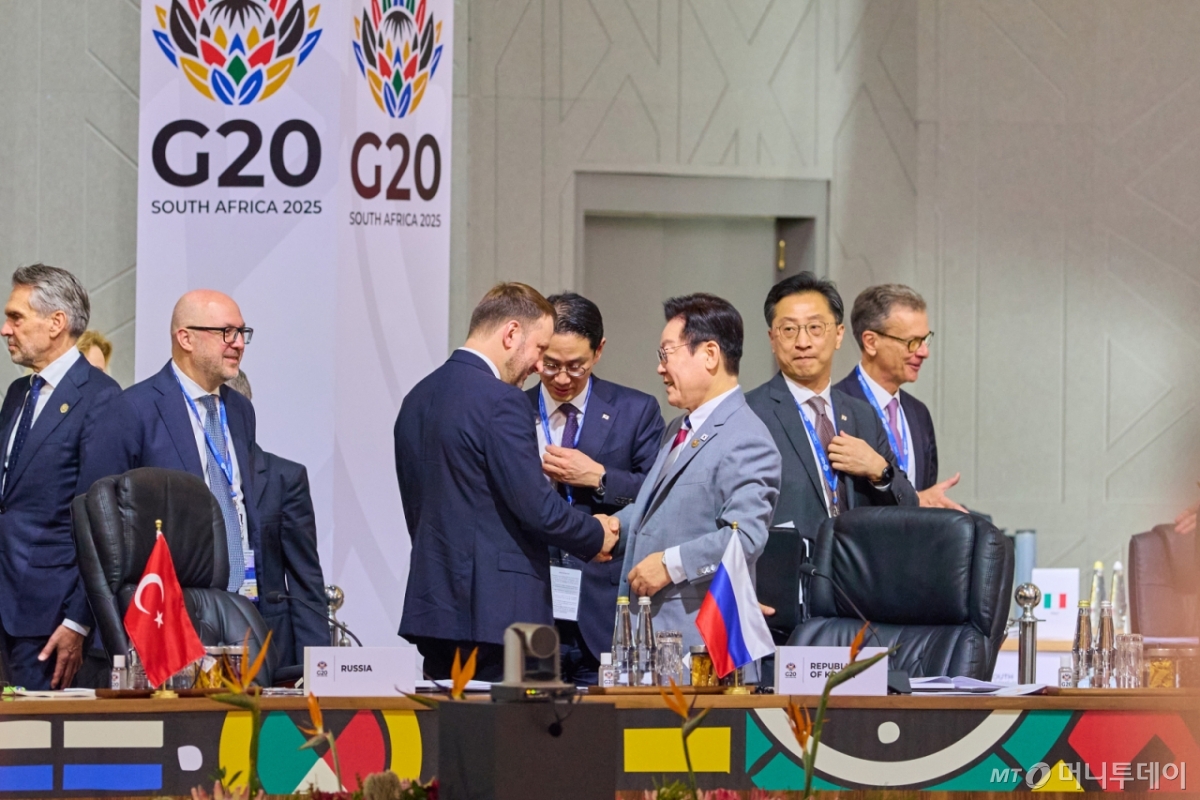 [요하네스버그=뉴시스] 최동준 기자 = 이재명 대통령이 22일(현지 시간) 남아프리카공화국 요하네스버그 엑스포 센터에서 열린 G20 정상회의에서 막심 오레쉬킨 러시아 대통령실 부비서실장과 악수를 하고 있다. (공동취재) 2025.11.22. photocdj@newsis.com /사진=