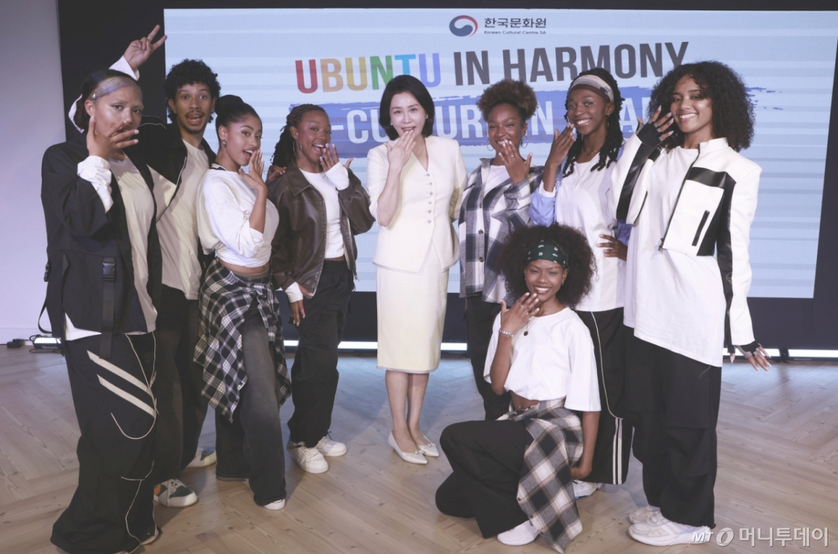 [요하네스버그=뉴시스] 최동준 기자 = 이재명 대통령과 함께 남아프리카공화국을 방문 중인 김혜경 여사가 22일(현지 시간) 요하네스버그 주남아공한국문화원에서 열린 한-남아공 음식문화 만남 및 문화원 학생 격려 행사에서 K팝 공연팀과 기념촬영을 하고 있다. 2025.11.22. photocdj@newsis.com /사진=최동준