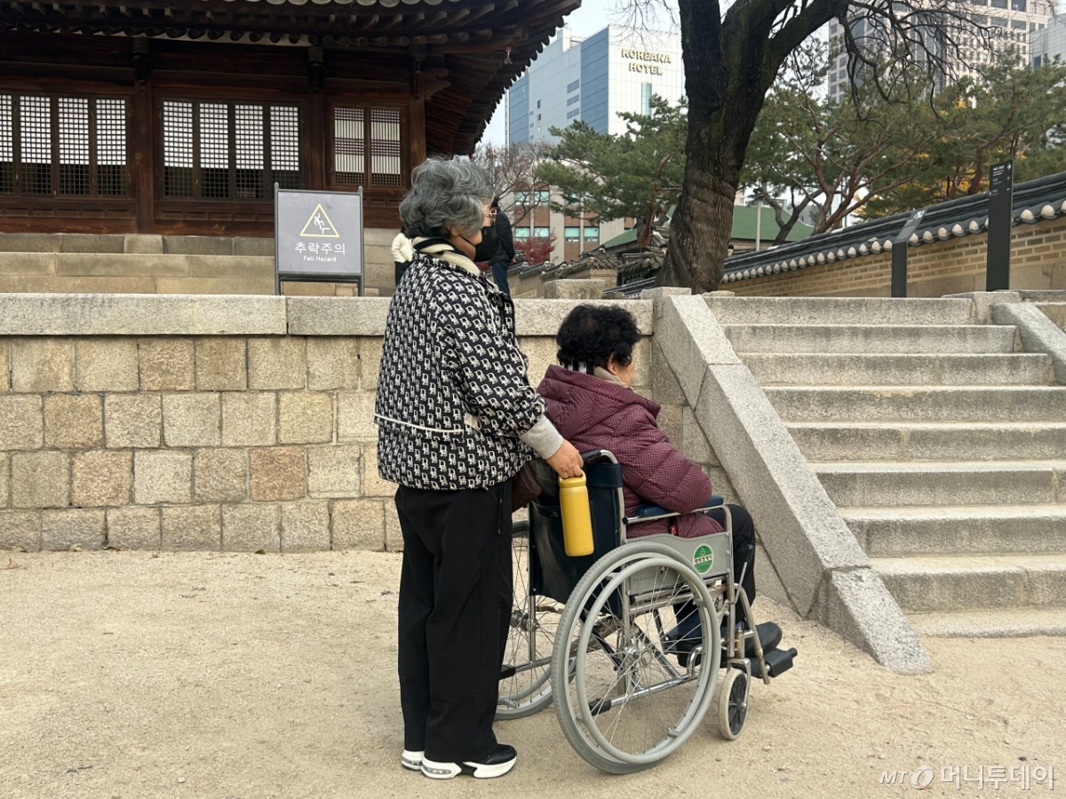 지난 20일 서울 덕수궁에서 만난 휠체어를 탄 어머니 손태선씨(76)와 휠체어 손잡이를 잡고 있는 딸 권명옥씨(56). /사진=김지현 기자.