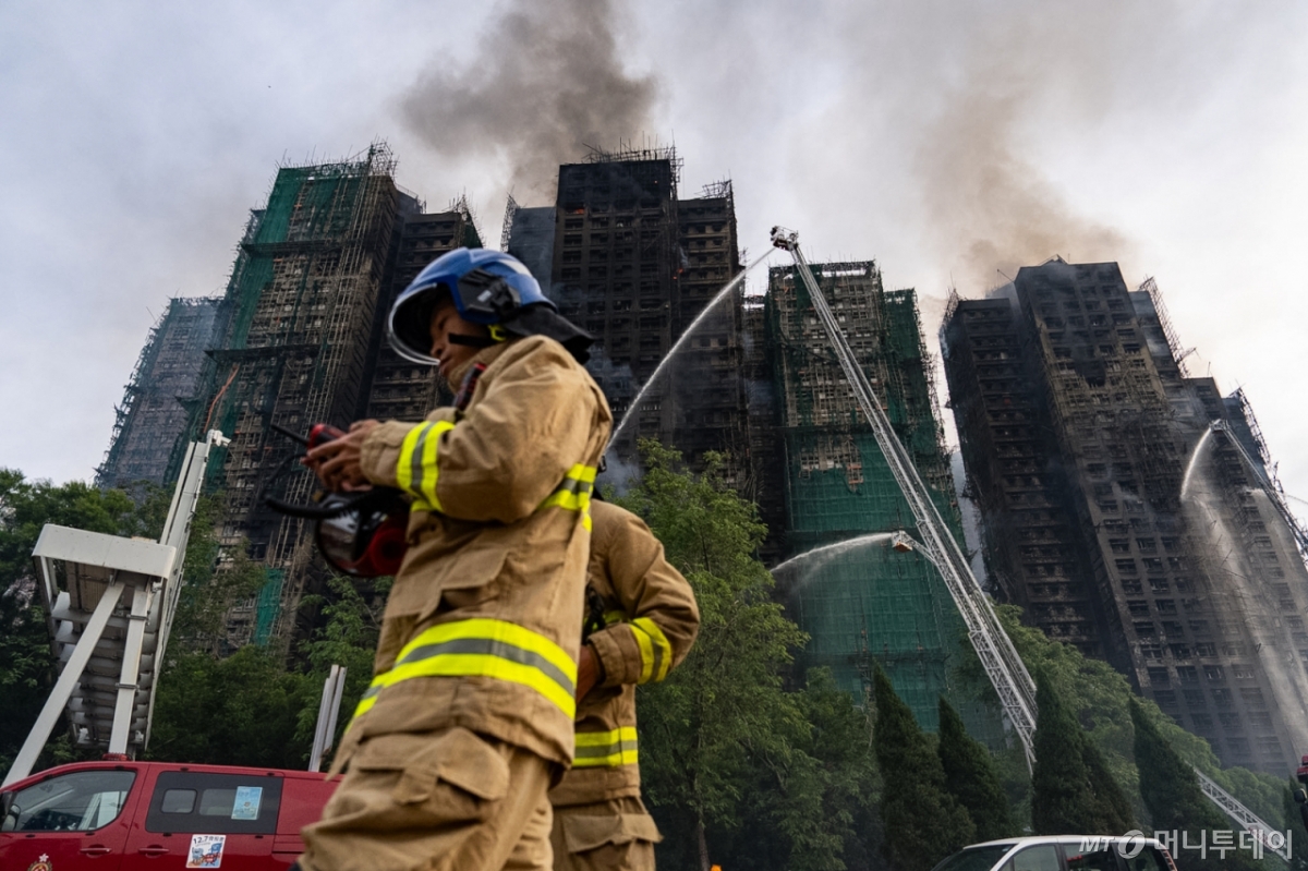 [홍콩=AP/뉴시스] 27일(현지 시간) 홍콩 북부 타이포 구역의 '웡 푹 코트' 아파트 단지에서 소방관들이 화재를 진압하고 있다. 전날 발생한 이 화재로 31층 아파트 8개 동 중 7개 동에 불이 번졌고 소방관 포함 최소 44명이 숨졌으며 45명이 부상하고 279명이 실종된 것으로 알려졌다. 2025.11.27. /사진=민경찬