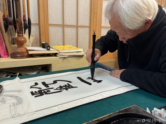 문씨가 고사성어 '공휴일궤'를 한자로 써 내려가고 있다. /사진=최문혁 기자. 