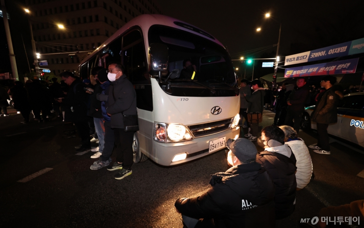 (서울=뉴스1) 구윤성 기자 = 윤석열 대통령이 비상계엄령을 전격 선포한 가운데 4일 새벽 서울 여의도 국회로 진입하려는 계엄군 차량을 시민들이 막아서고 있다. 2024.12.4/뉴스1  Copyright © 뉴스1. All rights reserved. 무단 전재 및 재배포,  AI학습 이용 금지. /사진=(서울=뉴스1) 구윤성 기자