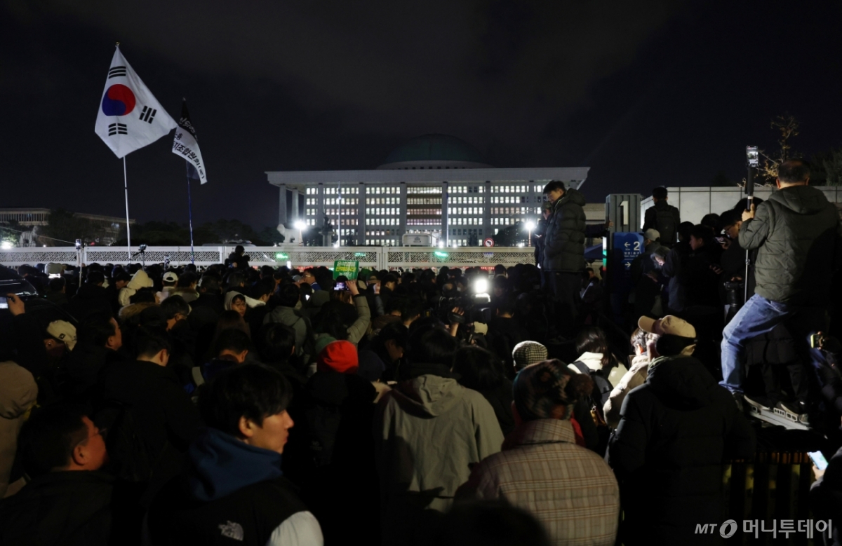 [서울=뉴시스] 김진아 기자 = 윤석열 대통령의 비상계엄 해제 요구 결의안이 국회 본회의에서 통과된 4일 새벽 서울 영등포구 국회 정문 앞에서 시민들이 윤석열 대통령 퇴진 촉구 구호를 외치고 있다. 2024.12.04. bluesoda@newsis.com /사진=김진아