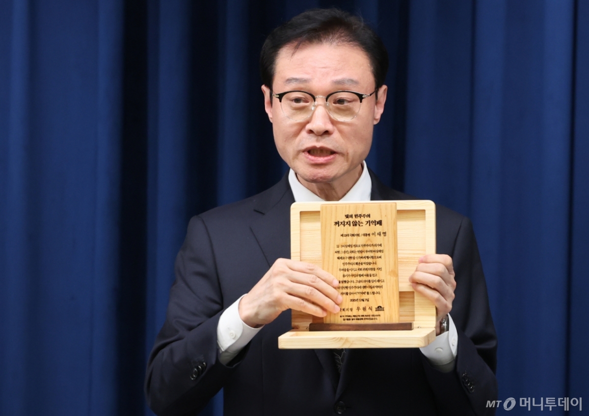 (서울=뉴스1) 허경 기자 = 이규연 홍보소통수석이 3일 서울 용산 대통령실 청사에서 열린 5부 요인 초청 오찬 관련 브리핑에서 '빛의 민주주의 꺼지지 않는 기억패'를 들어보이고 있다.  이재명 대통령은 이날 오찬에서 우원식 국회의장으로부터 지난해 12월 3일 계엄군에 의해 부서졌던 국회 집기들을 재활용해 만든 '기억패'를 전달 받았다. 2025.12.3/뉴스1  Copyright © 뉴스1. All rights reserved. 무단 전재 및 재배포,  AI학습 이용 금지. /사진=(서울=뉴스1) 허경 기자