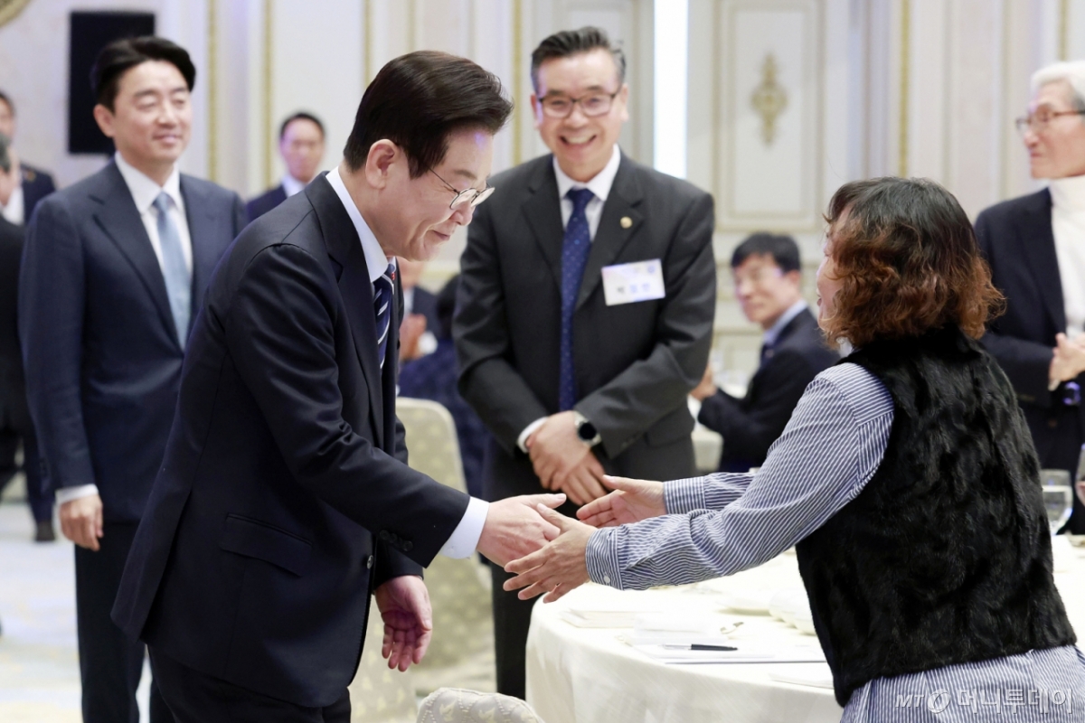 [서울=뉴시스] 최동준 기자 = 이재명 대통령이 4일 청와대 영빈관에서 열린 산업 역군 초청 오찬 행사에 입장하며 구로공단 1세대 여성 노동자이자 봉제산업 장인인 미싱사 강명자 씨와 악수하고 있다.  이번 행사는 무역의 날을 맞아 조선, 자동차, 섬유, 전자, 기계, 방산, 해운 등에서 대한민국 경제발전에 헌신해 온 산업 역군들을 재조명하고 그들의 노고에 대한 감사를 전하기 위해 마련됐다. 2025.12.04. photocdj@newsis.com /사진=최동준