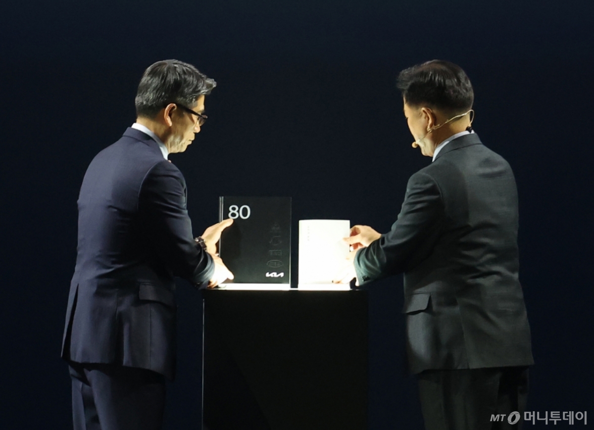 (용인=뉴스1) 김영운 기자 = 송호성 기아 대표이사 사장과 정의철 기아 기업전략실 전무가 5일 경기 용인시 처인구 기아 비전스퀘어에서 열린 '기아 80주년 기념식'에서 기아 80년 사사를 공개하고 있다. 2025.12.5/뉴스1  Copyright © 뉴스1. All rights reserved. 무단 전재 및 재배포,  AI학습 이용 금지. /사진=(용인=뉴스1) 김영운 기자